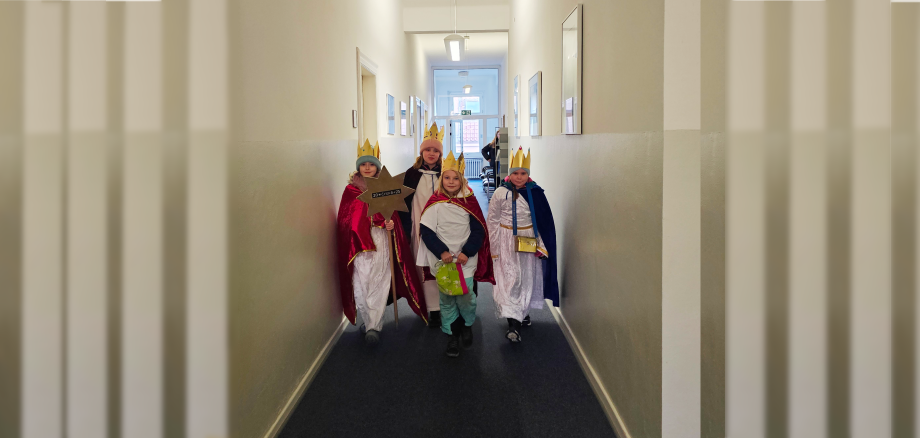 Sie sehen: Die Gruppe der Sternsinger wandert durch den Flur des Rathauses.