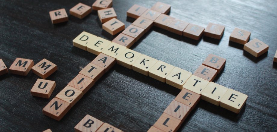 Sie sehen: ein Scrabble-Spiel mit Buchstaben der Begriffe: Demokratie, Bürger, Information, Beteiligung,  Recht.